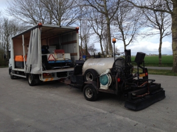 vrachtauto met sproeiunit en strooier